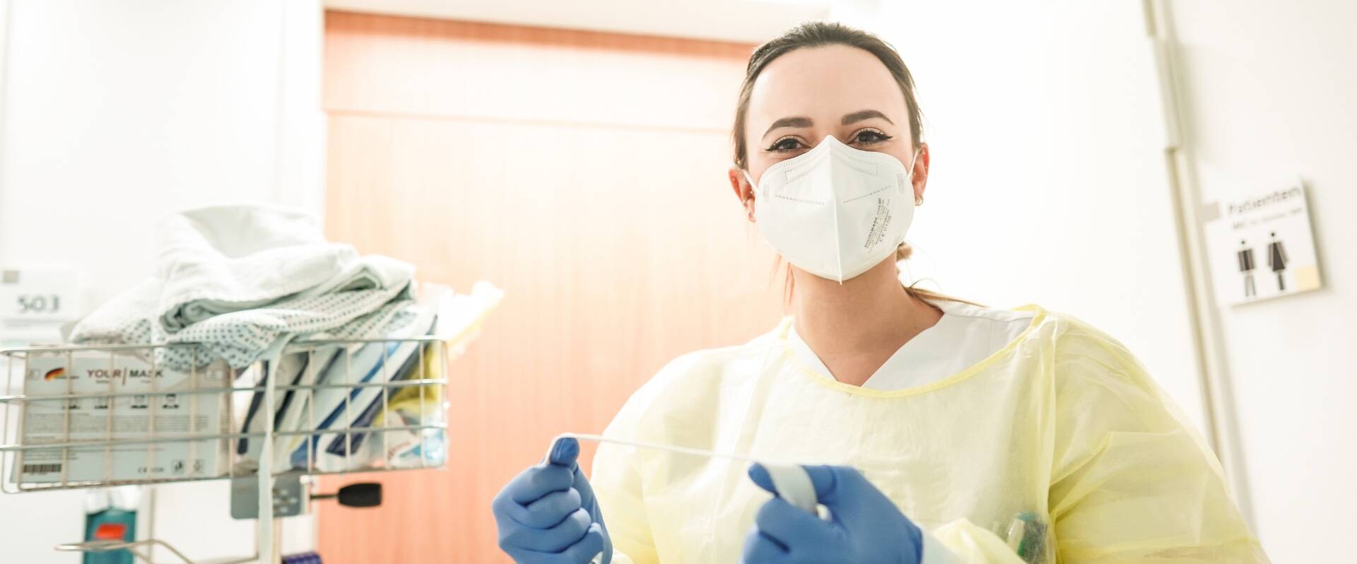 &Auml;rztin mit Maske und Handschuhe im Krankenhausflur