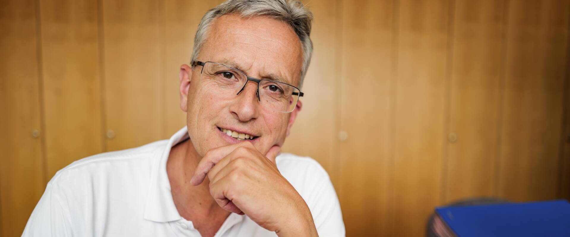 Denkender Arzt mit weißem Polo-Shirt